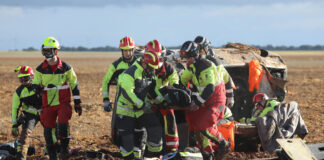 Bomberos de la capital (traje rojo y amarillo) y voluntarios de los parques de la Diputación (traje negro y amarillo) rescatan a una de las heridas en un accidente. / Brágimo (ICAL)