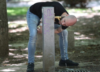 Hombre bebiendo agua de una fuente en Palencia