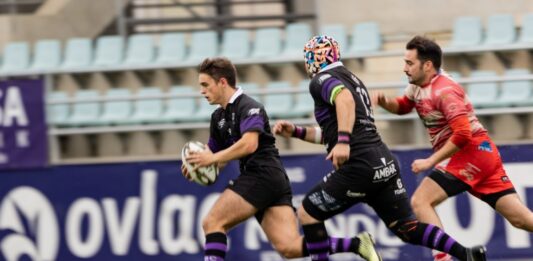 Guille corre portando el balón perseguido por un jugador de Arroyo y Vegas como apoyo. Rugby Palencia