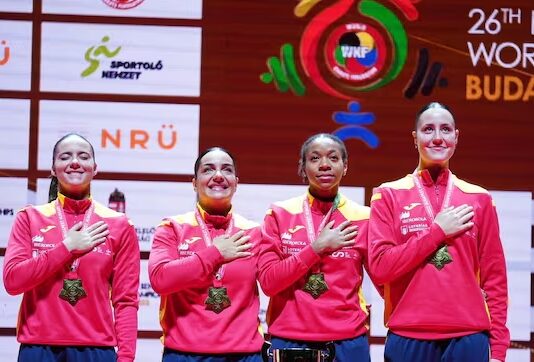 Nieto, segunda por la derecha, levanta junto a sus compañeras la copa de campeonas del mundo de karate